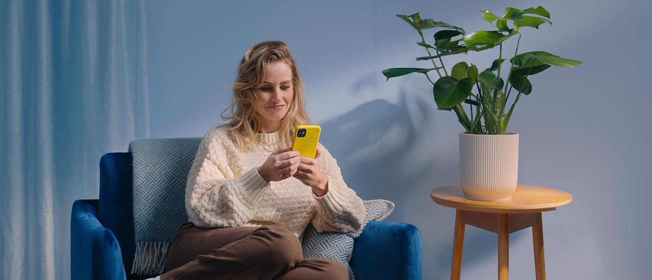 Vrouw zittend op stoel achter haar mobiel